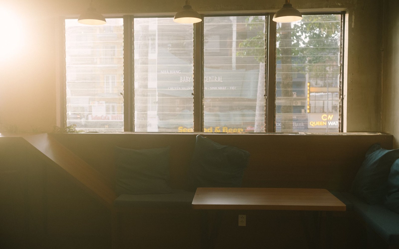 A corner booth with coats piled on the seat and two half-empty glasses on the table