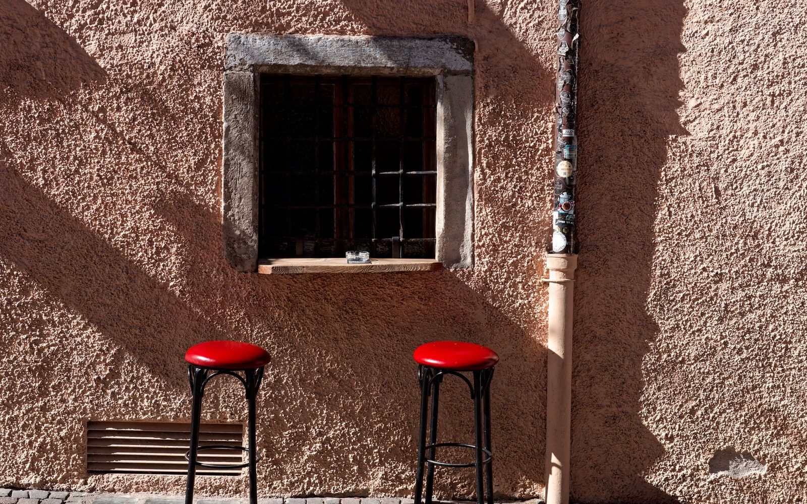 A taproom in the quiet hour before evening, bar stools still up on half the seats, afternoon light coming low through a street-level window